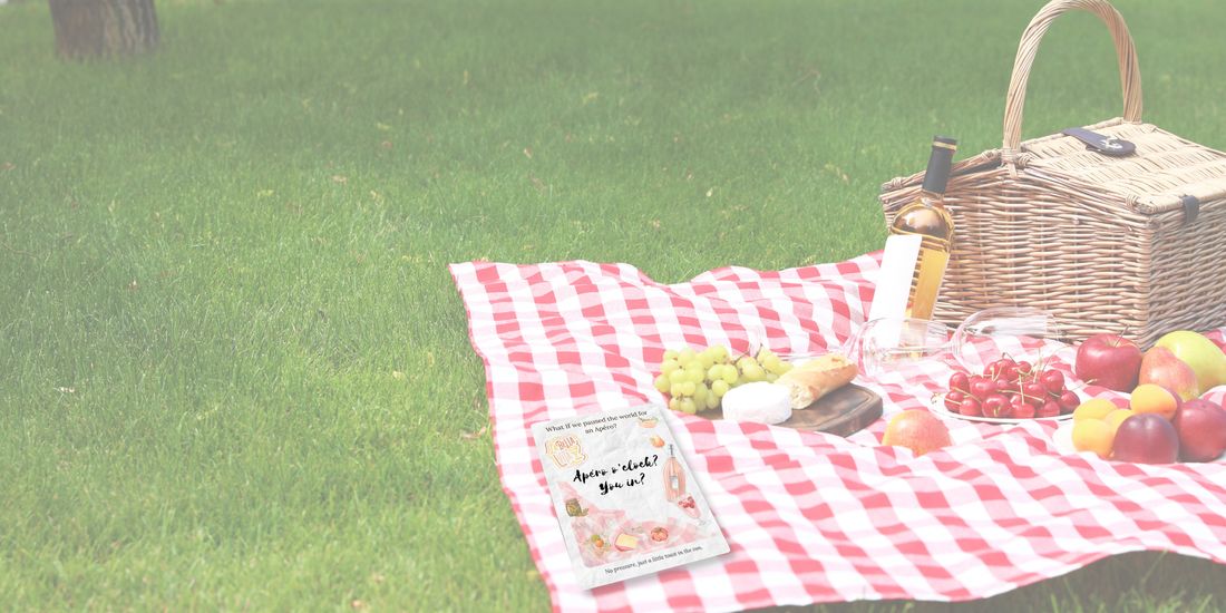 What-If Apéro Invite card displayed on a red picnic blanket with fruit, cheese, and rosé—summery flatlay for seasonal gatherings.