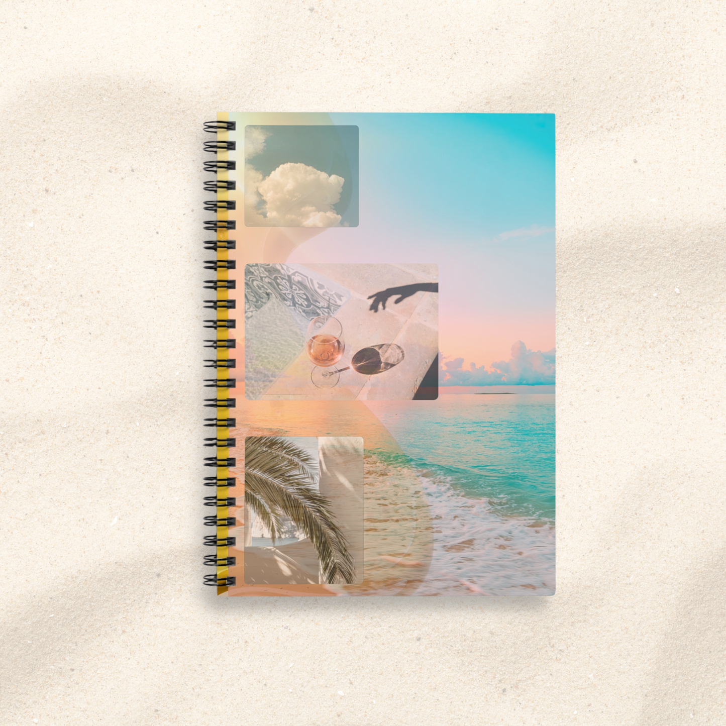 Golden Reverie spiral journal placed on soft sand background – surreal summer collage cover with ocean, palm, and rosé details, part of the Summer Reverie collection by Printed Echoes Creations.