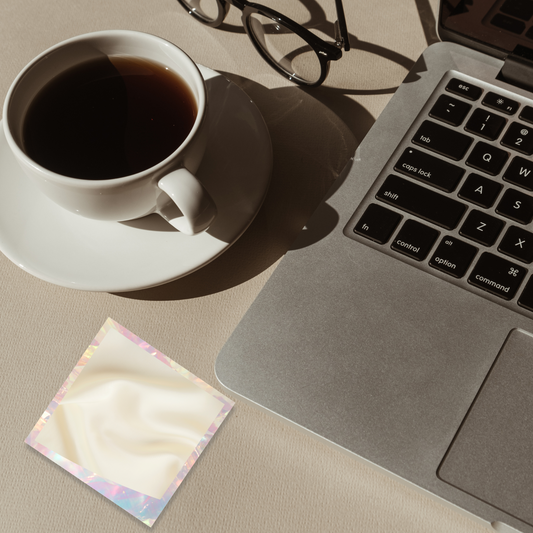 Morning light workspace with coffee cup, glasses, and laptop next to the holographic sticky note pad