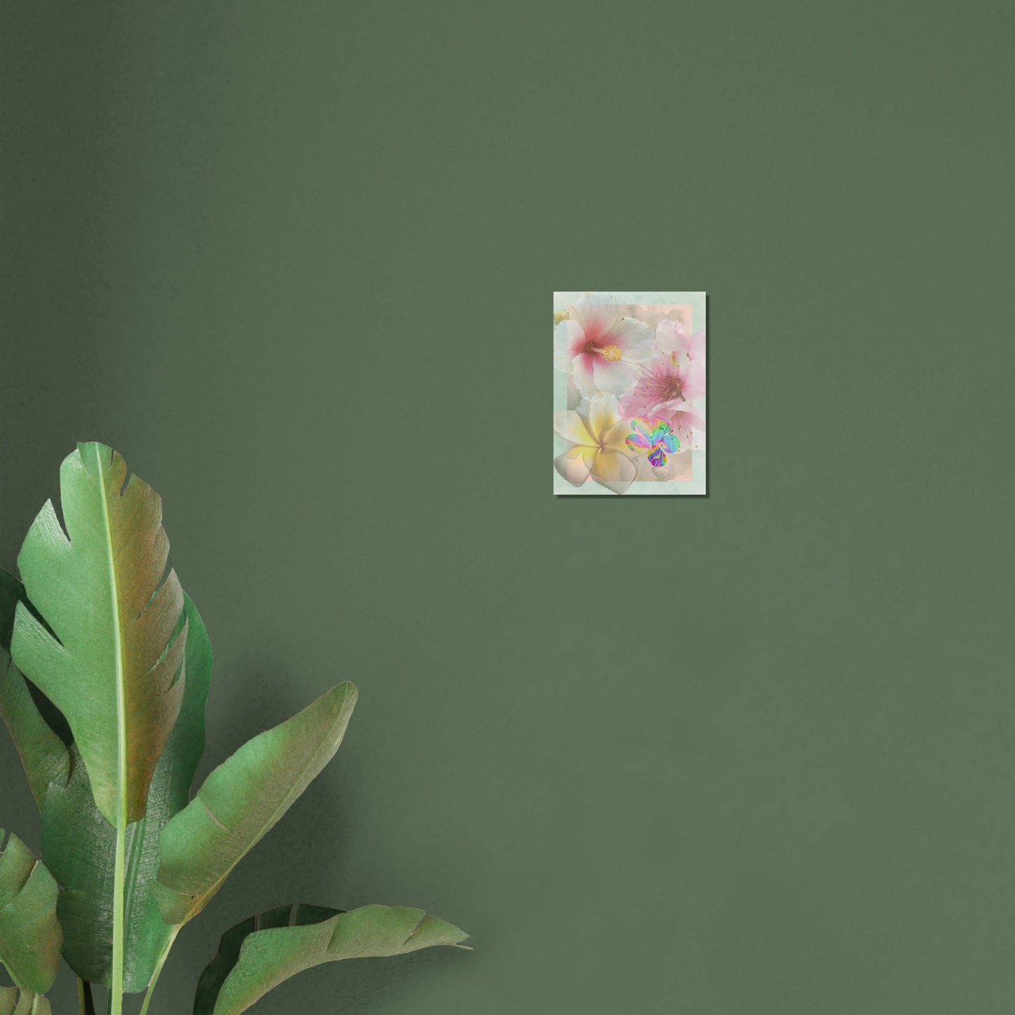 Small surreal floral art print displayed on a green wall with tropical leaves, showcasing dreamy hibiscus and iridescent accents.