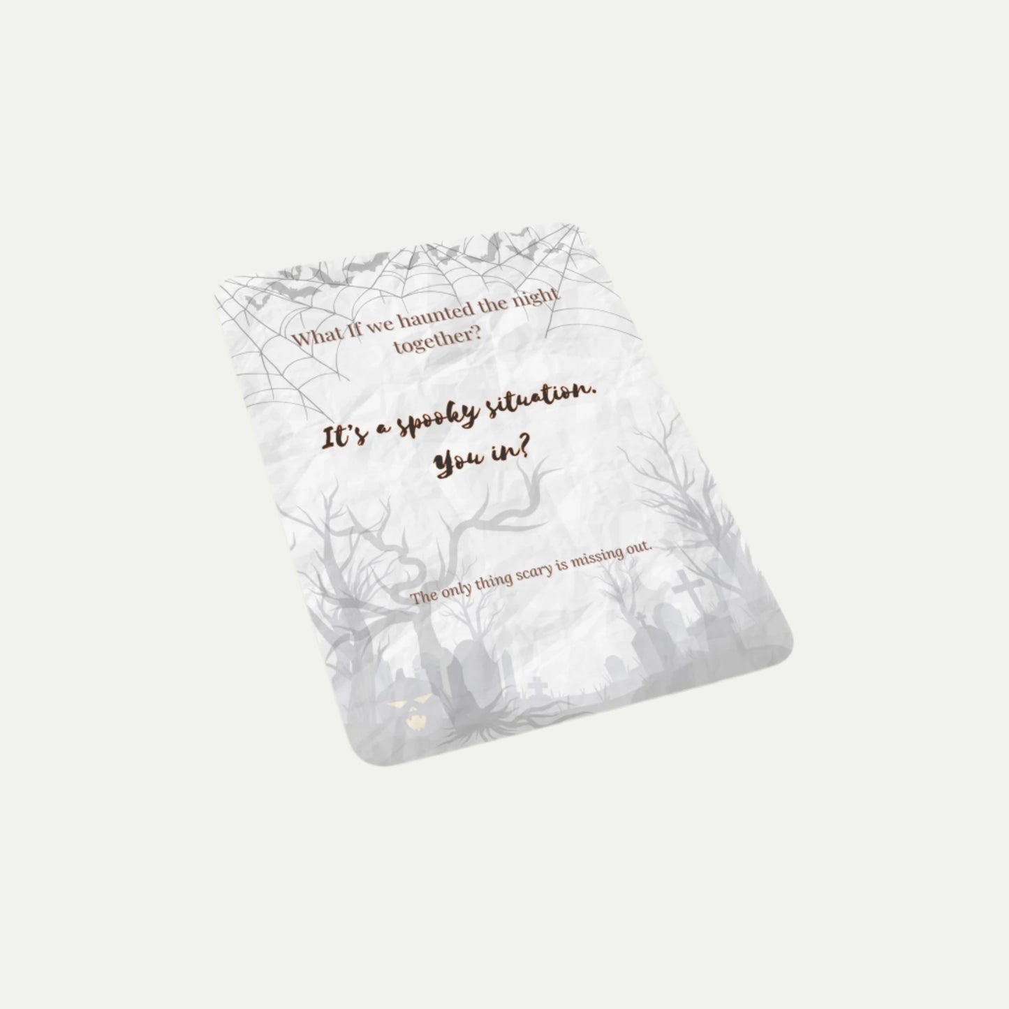 Angled view of the What If Halloween Invite card on a light background, featuring spooky illustrations and the phrase “It’s a spooky situation. You in?” — playful and minimalist seasonal design.