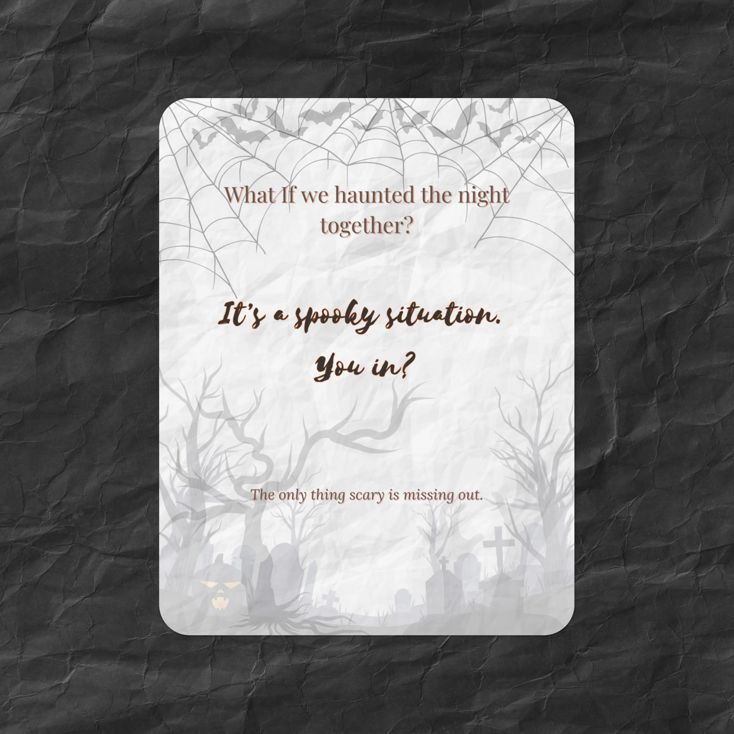Flat lay of the What If Halloween Invite card featuring the message “What if we haunted the night together?” with spooky trees, bats, and a crinkled dark paper background — a moody, casual art card for seasonal gatherings.