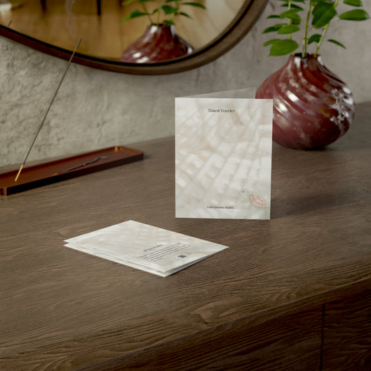 Tiniest Traveler baby card displayed on a wooden desk with incense and natural light. A poetic, minimalist greeting card with soft earthy tones.