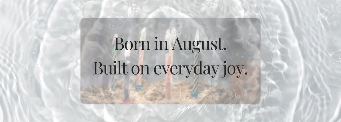 Birthday candles glowing softly under water-like light, paired with poetic text “Born in August. Built on everyday joy.” A dreamy, nostalgic visual reflecting summer birthdays and quiet celebration.