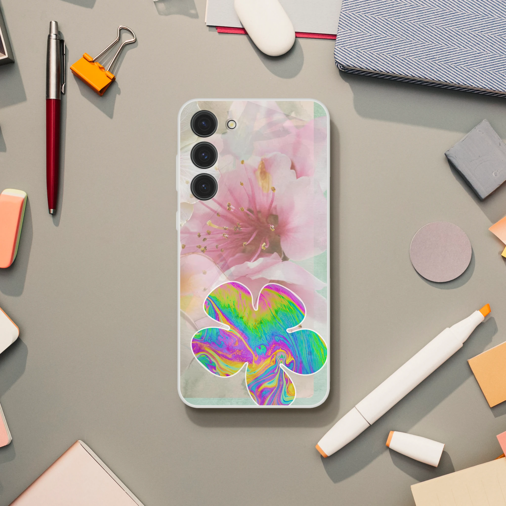 Samsung Galaxy S23+ phone case on a neutral desk, featuring a pink cherry blossom design and a bold psychedelic flower – slim, shock-resistant, and aesthetic.
