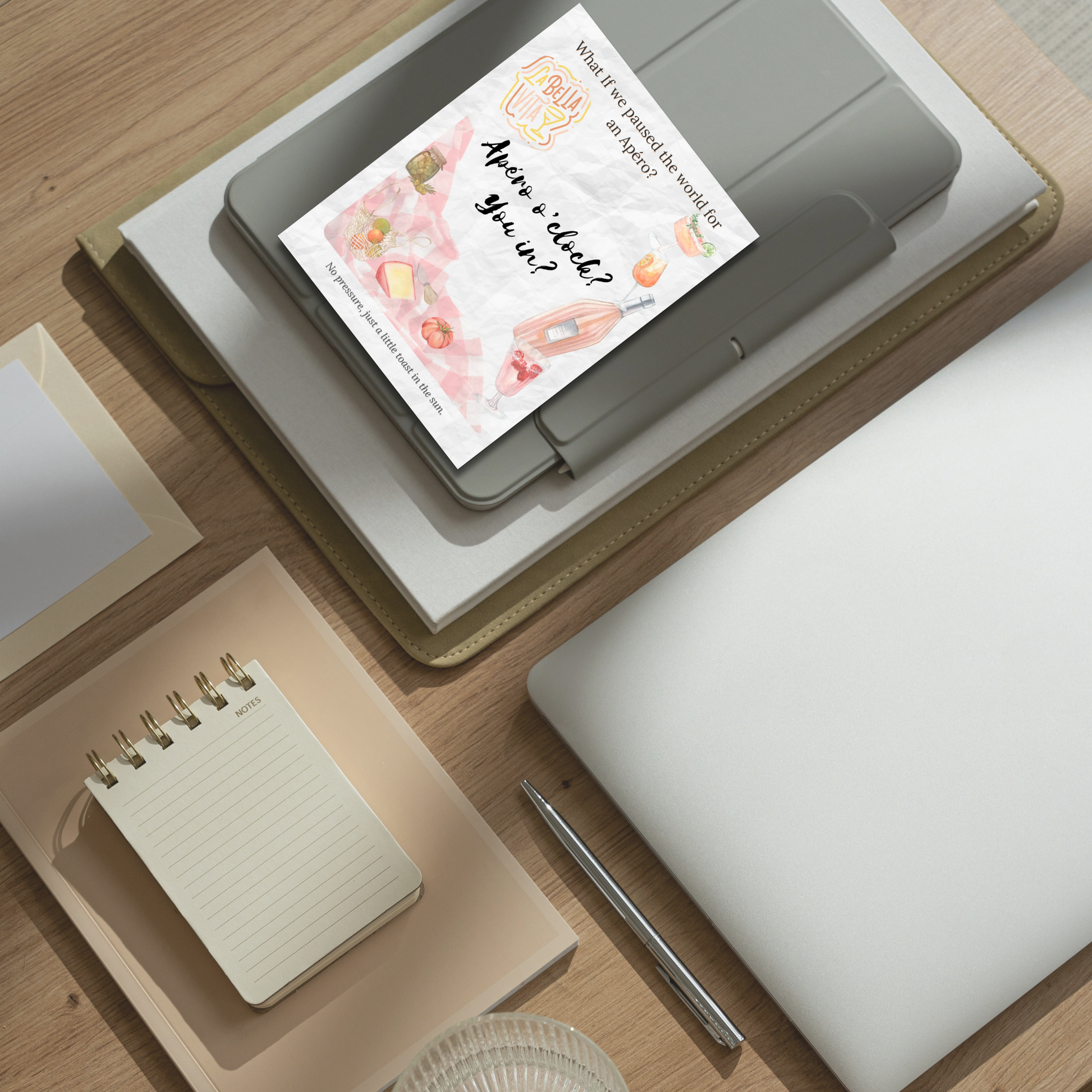 What-If Apéro Invite card displayed on a tidy desk with neutral stationery, showing the card’s flat format and poetic summer design by Printed Echoes Creations.
