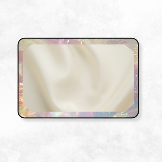 Soft-touch desk mat with iridescent frame and cream-toned fabric texture, laid flat against a white surface