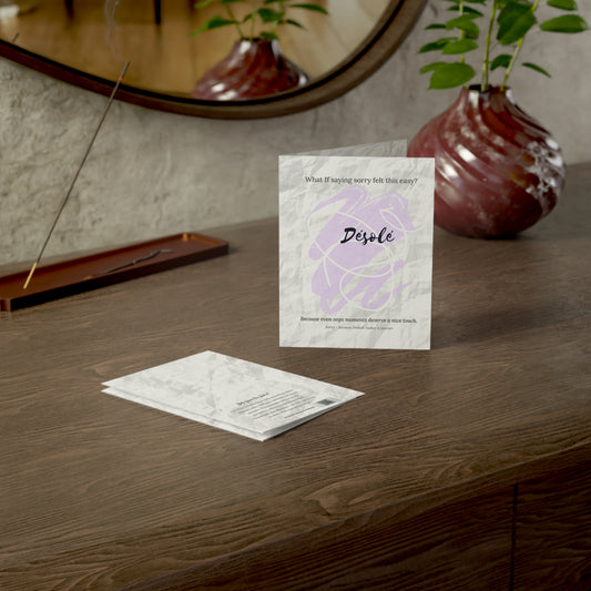 The Désolé sorry card fron the What-If Collection by Printed Echoes Creations, styled on a wooden desk with a modern vase and mirror in soft natural light.