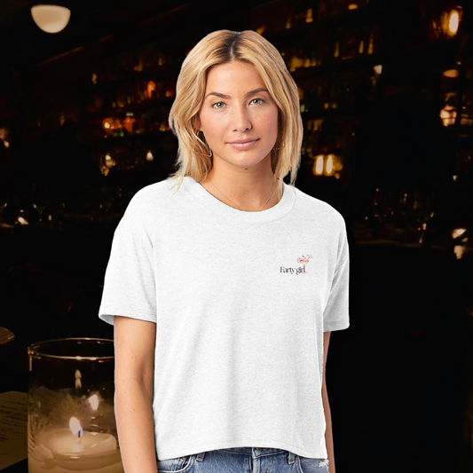 Model wearing the Farty Girl crop top with front logo design in a moody cocktail bar setting. Fun and minimalist, part of The Fart Club by Printed Echoes Creations.

