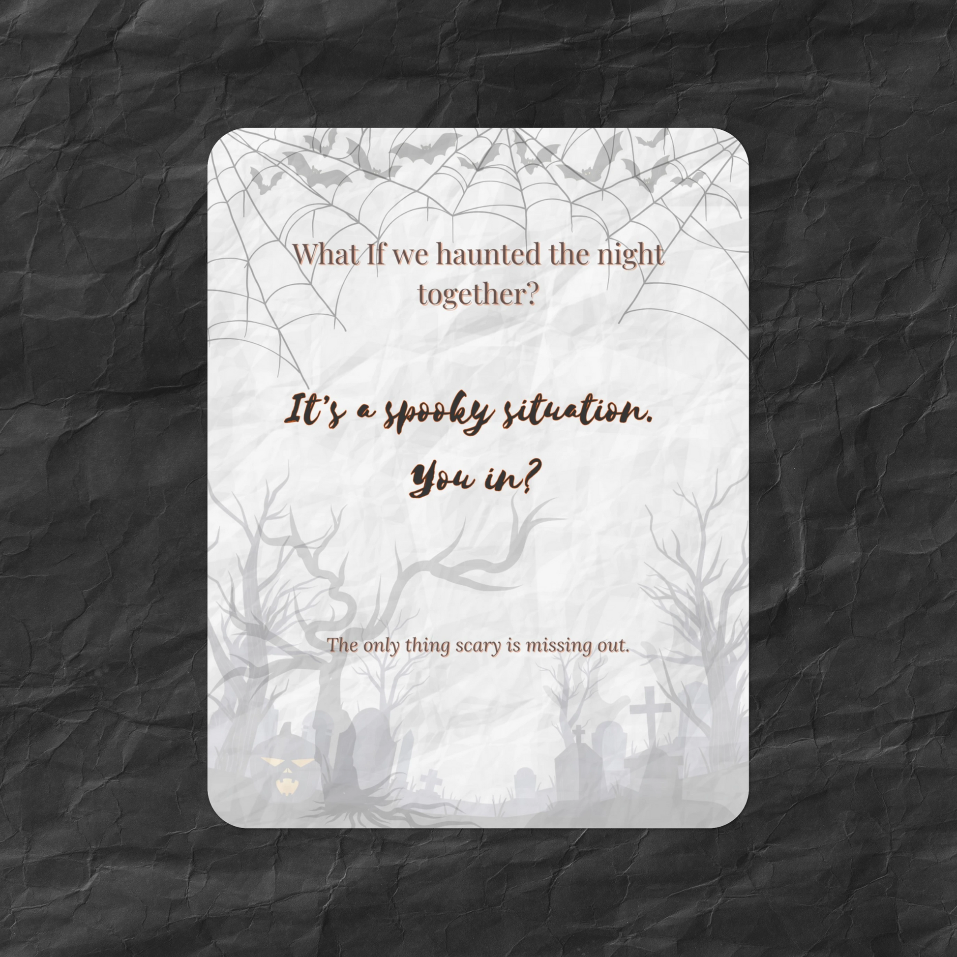 Flat lay of the What If Halloween Invite card featuring the message “What if we haunted the night together?” with spooky trees, bats, and a crinkled dark paper background — a moody, casual art card for seasonal gatherings.
