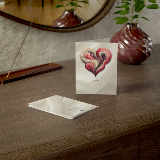 The “Love in Flow” abstract heart card styled on a wooden desk beside a soft glass vase and mirror, perfect for romantic or heartfelt occasions.

