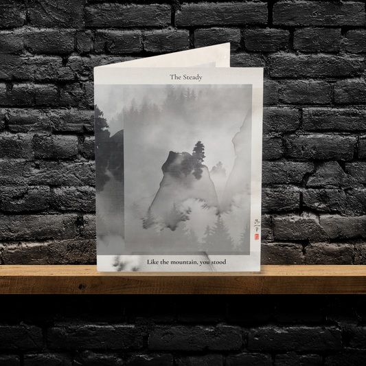A folded A6 art greeting card titled “The Builder,” featuring an abstract watercolor design in warm orange, yellow, and soft blue tones. Displayed upright on a wooden shelf against a black brick wall. A minimalist greeting card perfect for Father’s Day, appreciation, or gifting to a stepdad or mentor.

