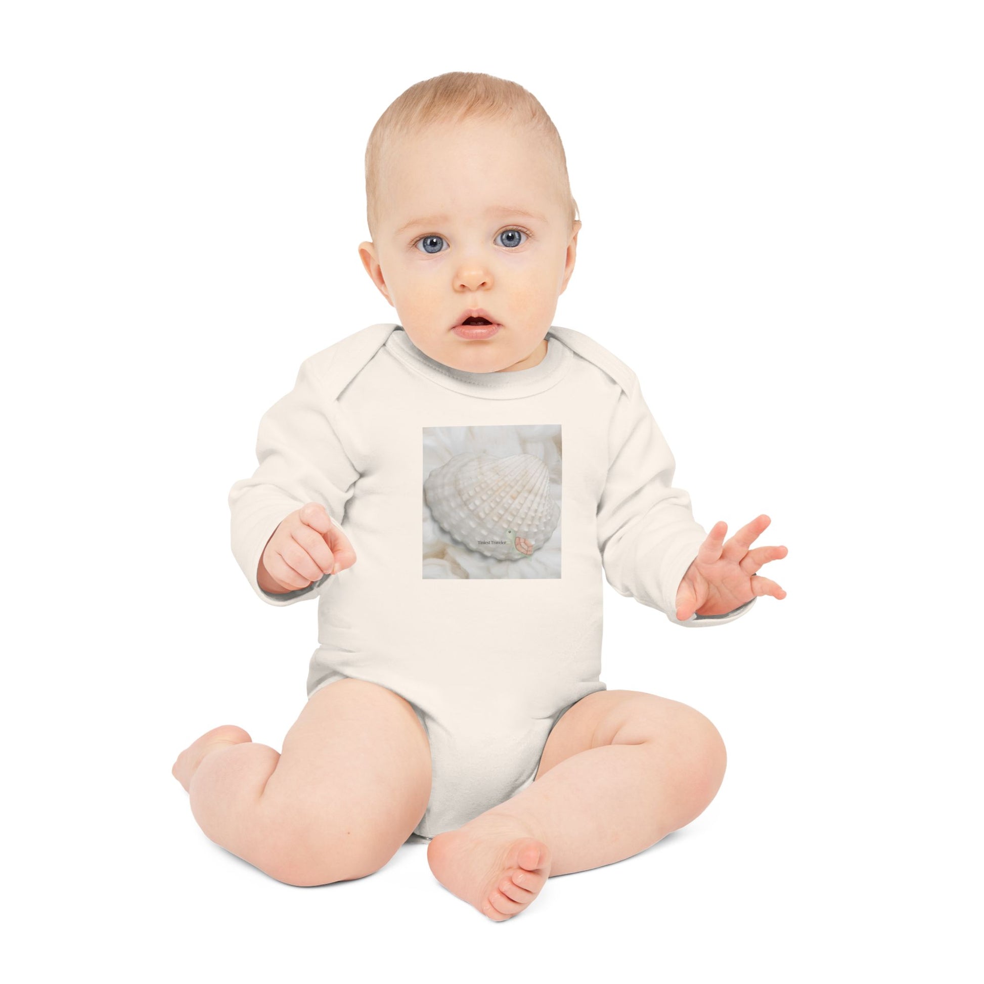Baby wearing the Tiniest Traveler bodysuit in organic natural cotton, soft-toned and serene.