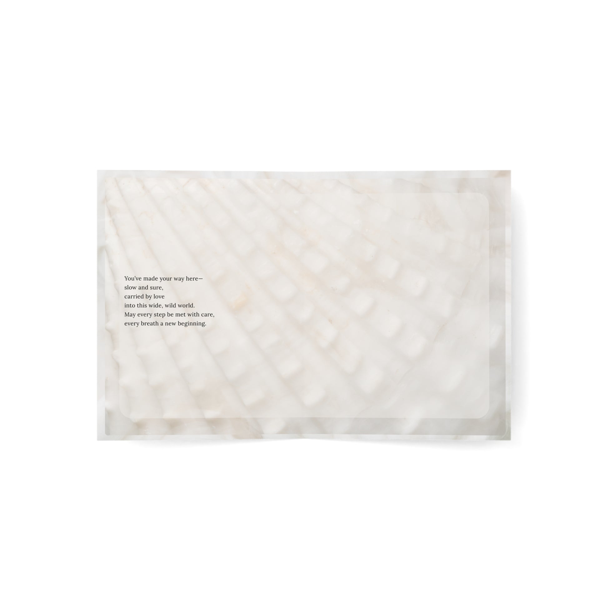 Flat lay of the inside of the Tiniest Traveler baby card, featuring a poetic birth message printed on a soft cotton-textured background.