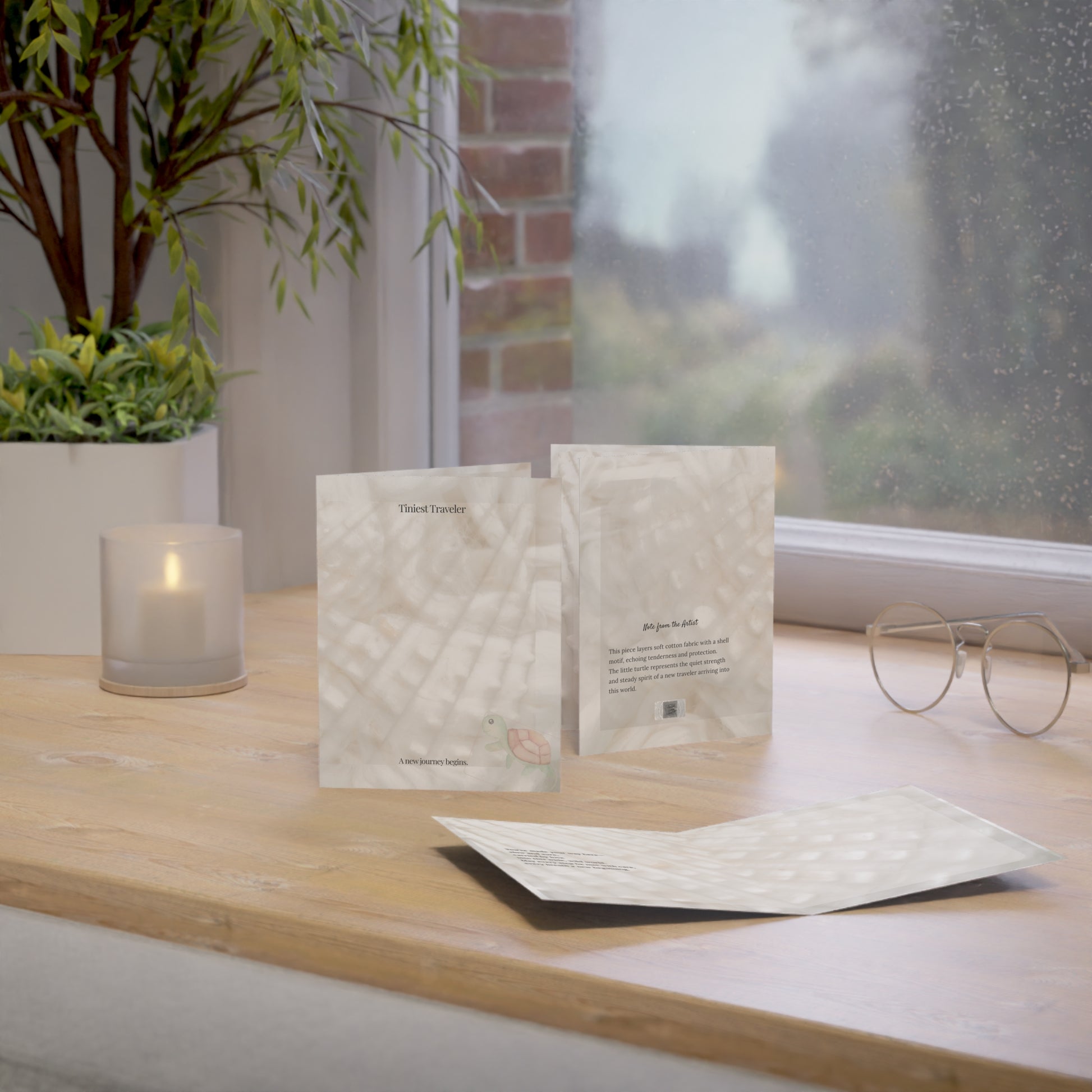 Soft baby card with turtle illustration on cotton texture, styled on a wooden table by a candle-lit window — calm and poetic.